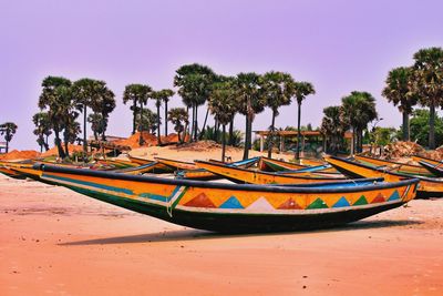 Boats moored on beach against clear sky