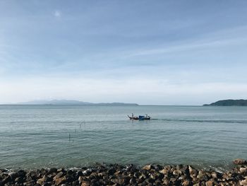 Boat sailing in sea against sky