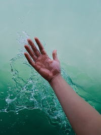 Cropped image of person splashing water