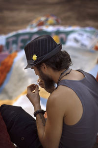 High angle view of man holding weed while sitting at salvation mountain