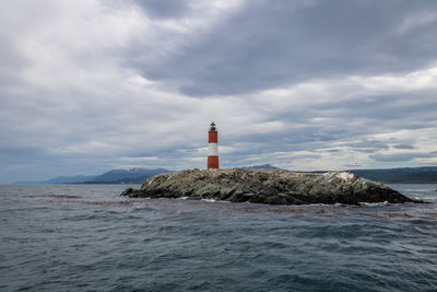 Lighthouse by sea against sky