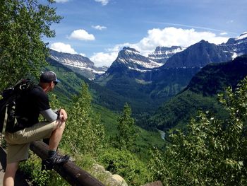 People sitting on mountains against sky