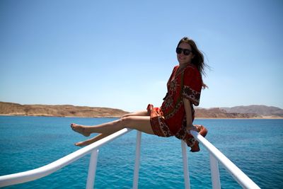 Woman sitting on railing