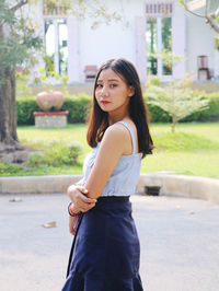 Beautiful young woman looking down while standing outdoors