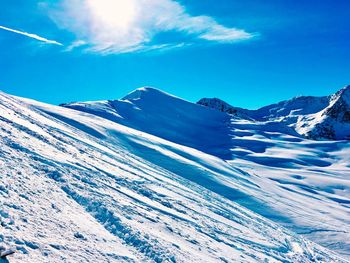 Scenic view of snowcapped mountains against blue sky