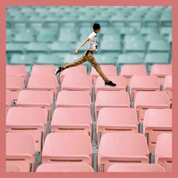 Side view of man standing on empty chairs