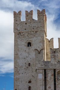 Low angle view of old building against cloudy sky