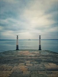 Lighthouse by sea against sky