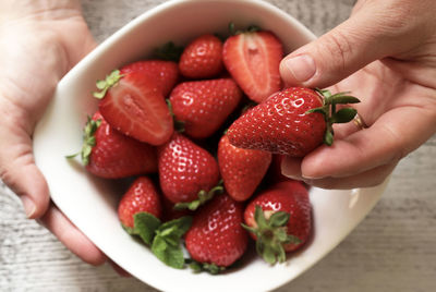 Close-up of hand holding strawberries