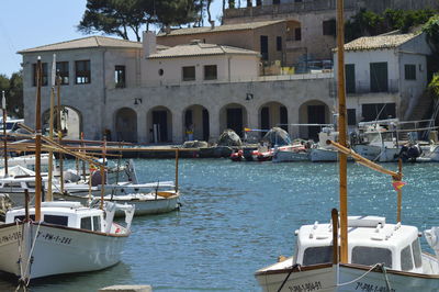 Boats moored at harbor against building