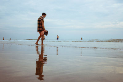 Rear view of man walking at beach