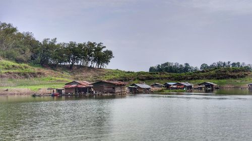 Scenic view of lake by building against sky