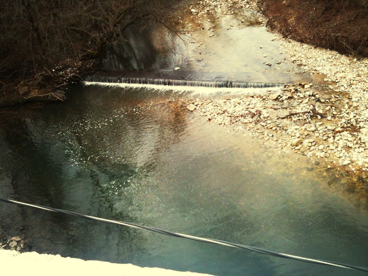 water, reflection, high angle view, wet, puddle, nature, day, river, tranquility, outdoors, lake, no people, waterfront, road, sunlight, street, standing water, rain, beauty in nature, shadow