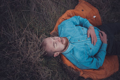 High angle view of man sleeping on field