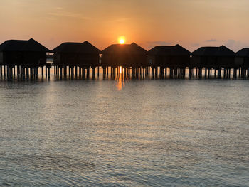 Maldives island sunset. water bungalows resort at islands beach