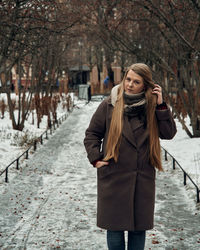 Woman standing on snow covered tree