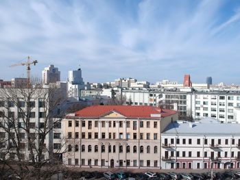 Buildings in city against cloudy sky