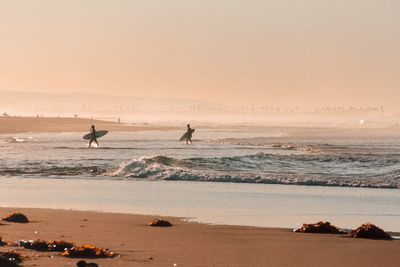 Silhouette of surfers at beach