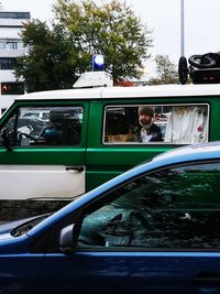 View of man sitting on car window