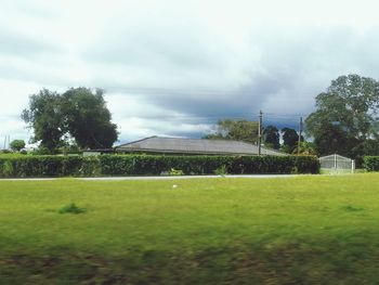 Scenic view of grassy field against cloudy sky