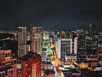 Illuminated buildings in city against sky at night