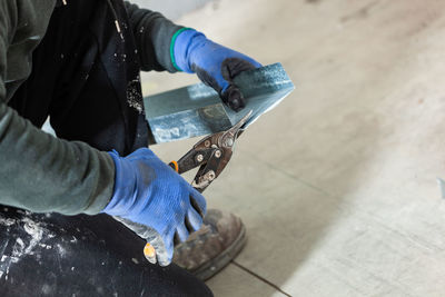 Low section of carpenter working on tiled floor