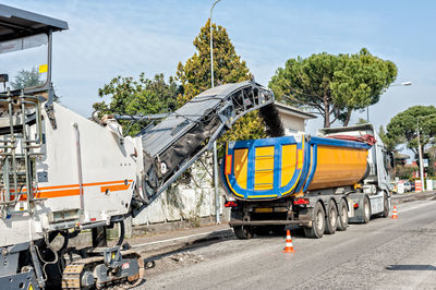 Milling machine on road against sky