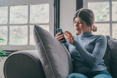 Young woman using mobile phone while sitting in car