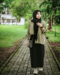 Young woman standing on footpath