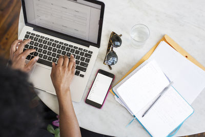 High angle view of woman using laptop computer at table