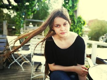 Portrait of young woman sitting outdoors