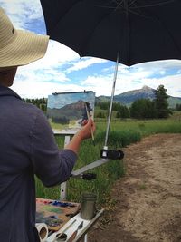 Rear view of woman painting landscape