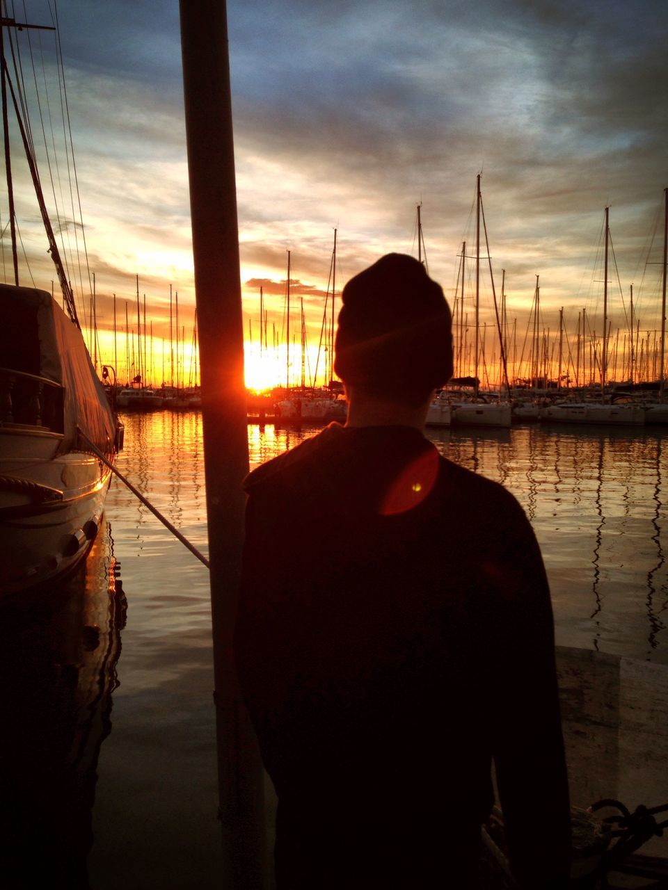 sunset, water, sky, lifestyles, nautical vessel, leisure activity, sea, cloud - sky, boat, transportation, silhouette, reflection, sitting, rear view, standing, mode of transport, men