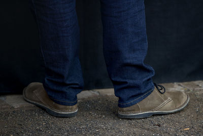 Low section of man standing on street