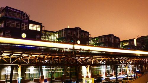 Low angle view of illuminated railroad station against sky at night