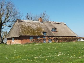 House on field against clear sky