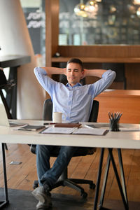 Portrait of young woman sitting on table