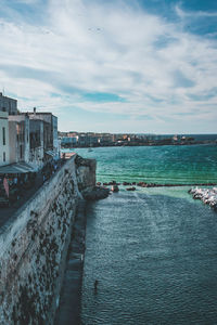 Scenic view of sea and buildings against sky