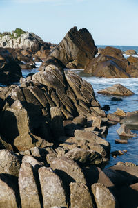 Rock formation on beach against clear sky