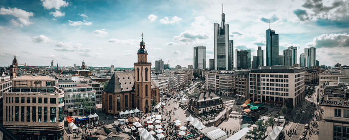 High angle view of city buildings against cloudy sky