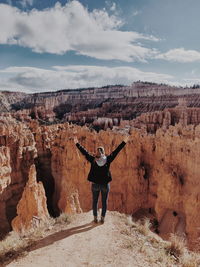 Rear view of woman with arms raised standing at bryce canyon