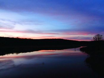 Reflection of clouds in calm lake at dusk