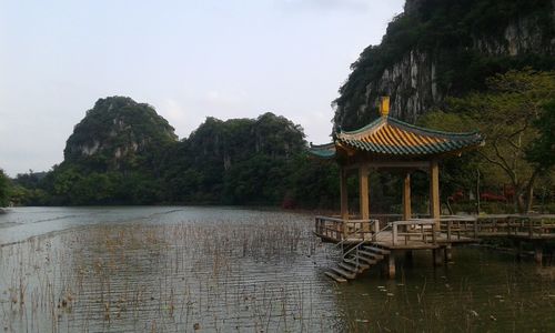 Gazebo by lake against sky