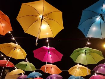 Low angle view of illuminated lighting equipment hanging in rain