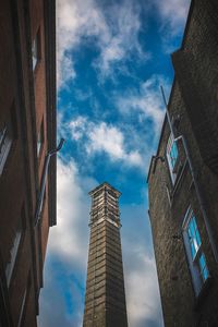 Low angle view of skyscrapers against cloudy sky