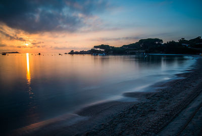 Scenic view of lake against sky at sunset