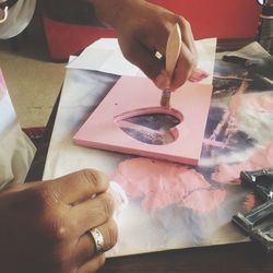 Cropped hand painting wooden heart shape