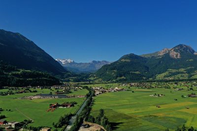 Scenic view of landscape and mountains against clear blue sky