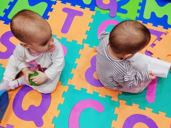 High angle view of cute siblings playing with toys