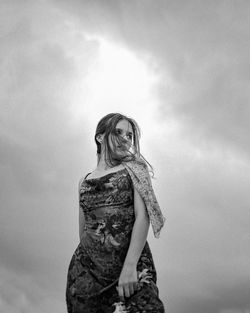 Low angle view of woman standing against sky